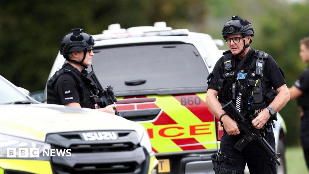 Armed police officers work on a road outside the perimeter of the RAF Fairford airbase